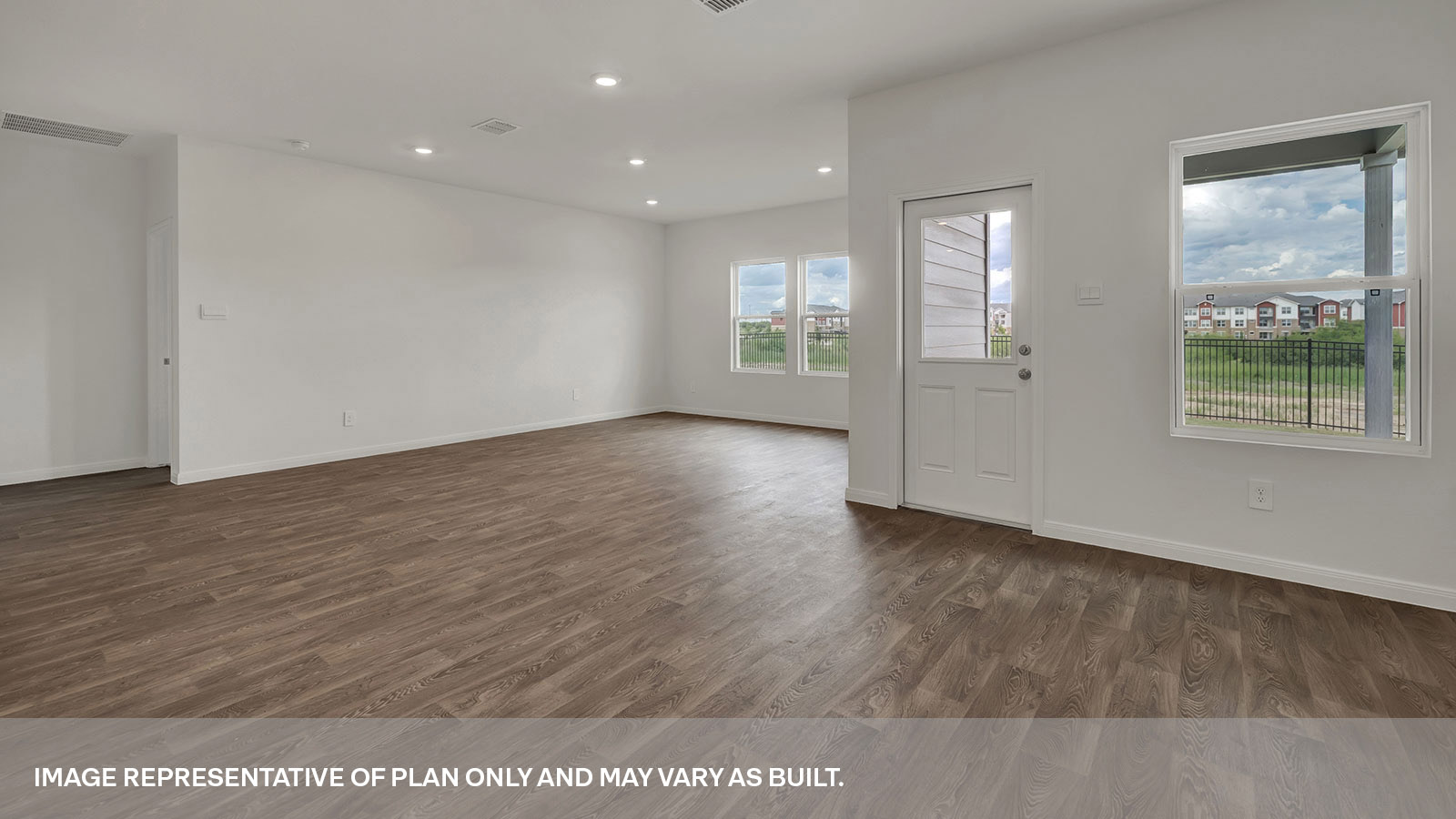 Dining room and living room with vinyl flooring, 3 windows, and a half lite exterior door.