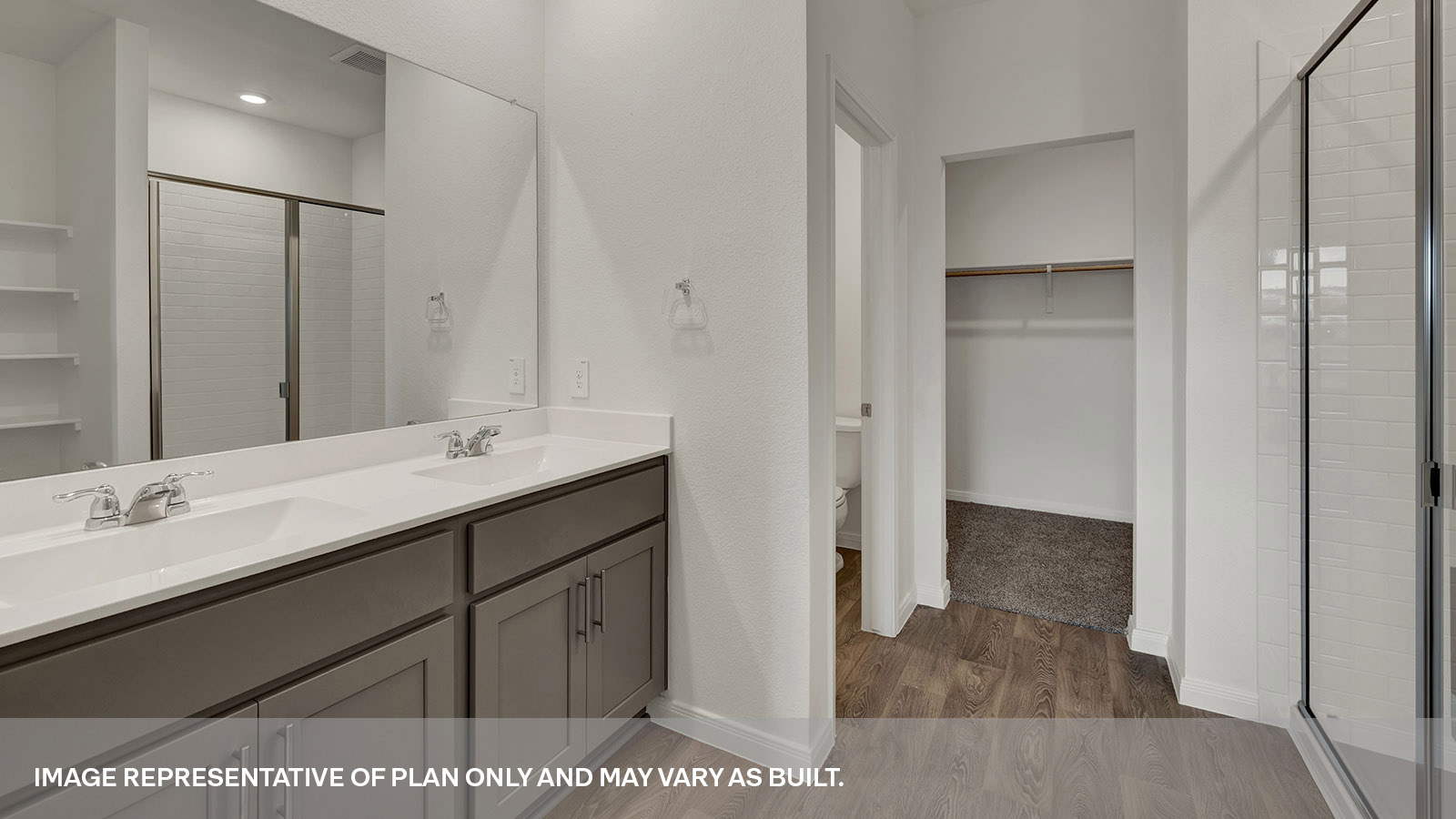 Main bathroom with double sink vanity and white cabinet, walk-in shower, and closet entry.