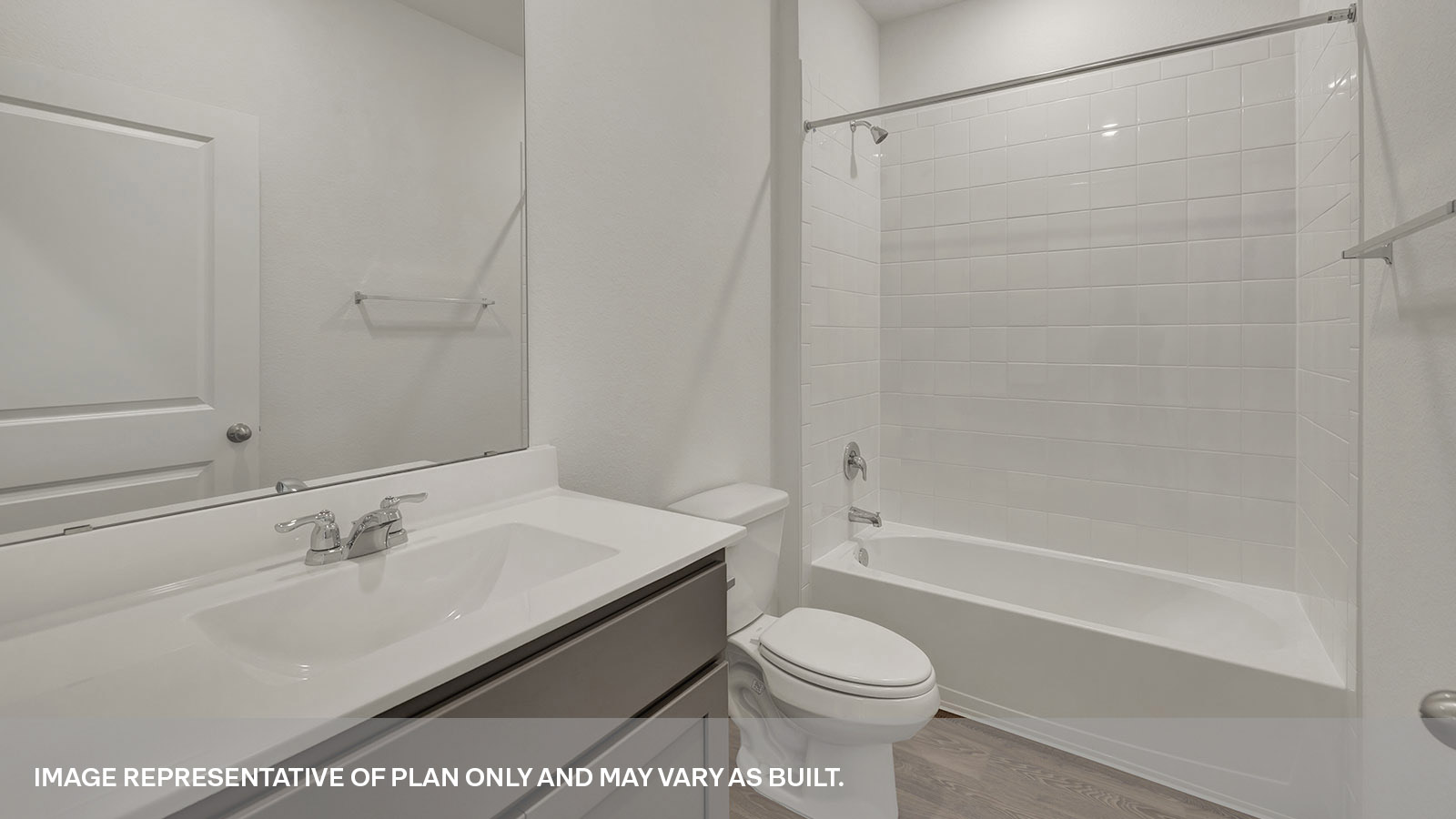 Bathroom with single sink vanity, toilet, and tile surround with tub/shower combo.