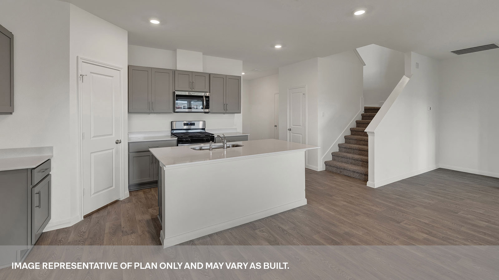 Kitchen with kitchen island and stairs to the 2nd floor.