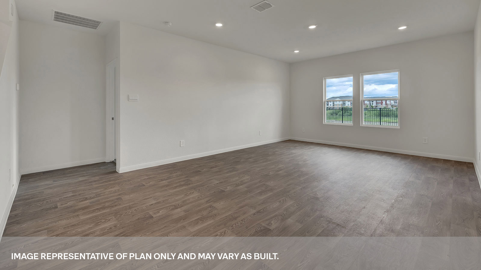 Living room with vinyl flooring and two windows.