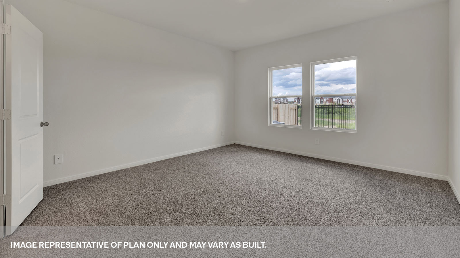 Main bedroom with carpeting and two windows.