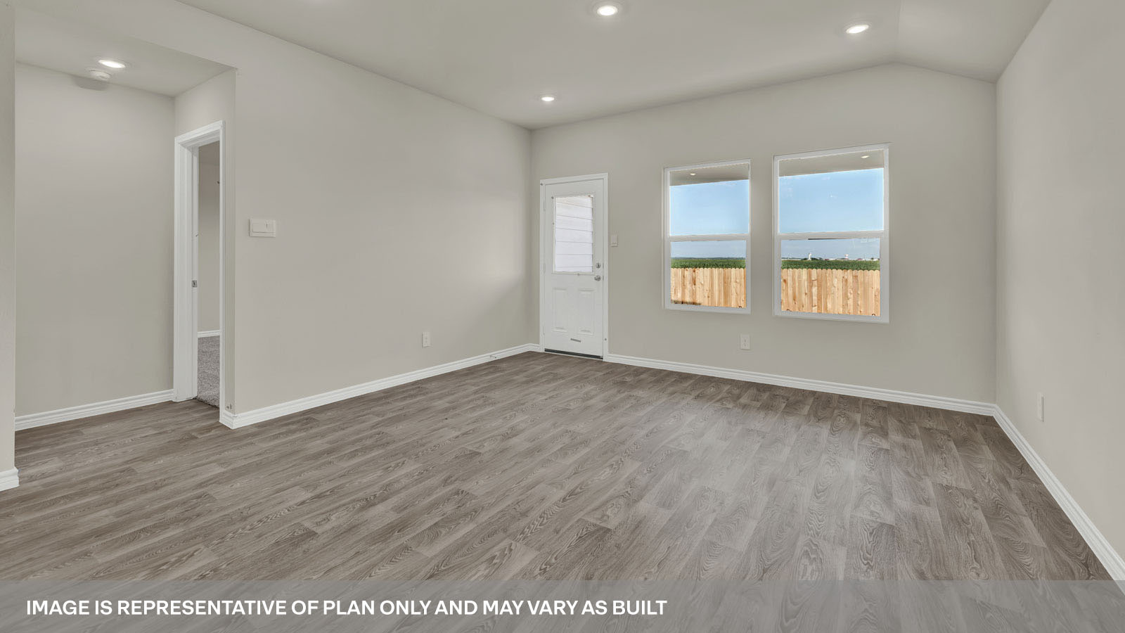 Living room with vinyl flooring, two windows, and a half lite exterior door.