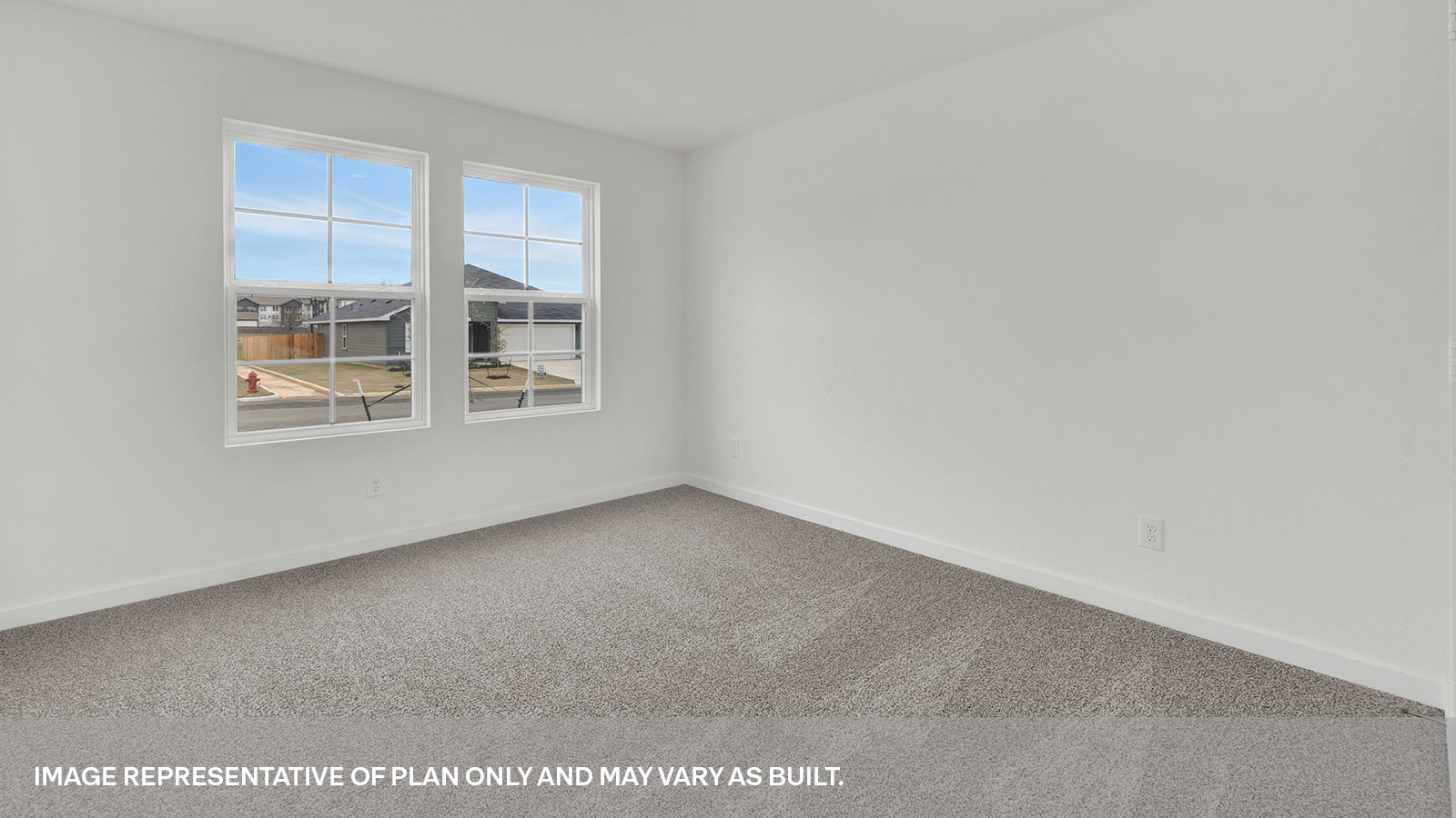 Front bedroom with carpeting and two windows.