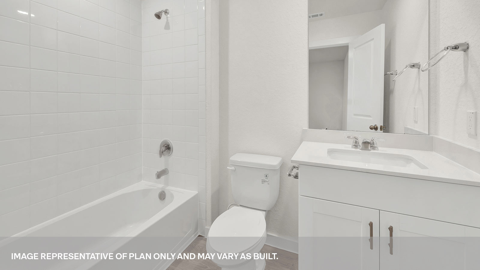 Hall bathroom with vanity, toilet, and tub with tile surround.