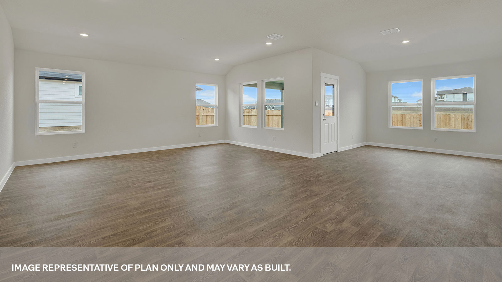 Living room and dining room with vinyl flooring, 4 windows, and a half lite exterior door.