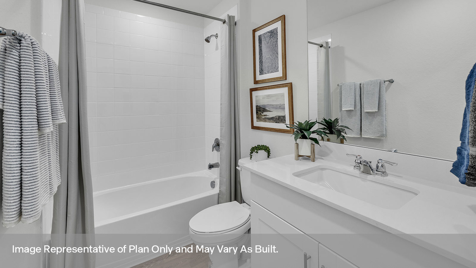 Hall bathroom with vanity, toilet, and tub with tile surround.