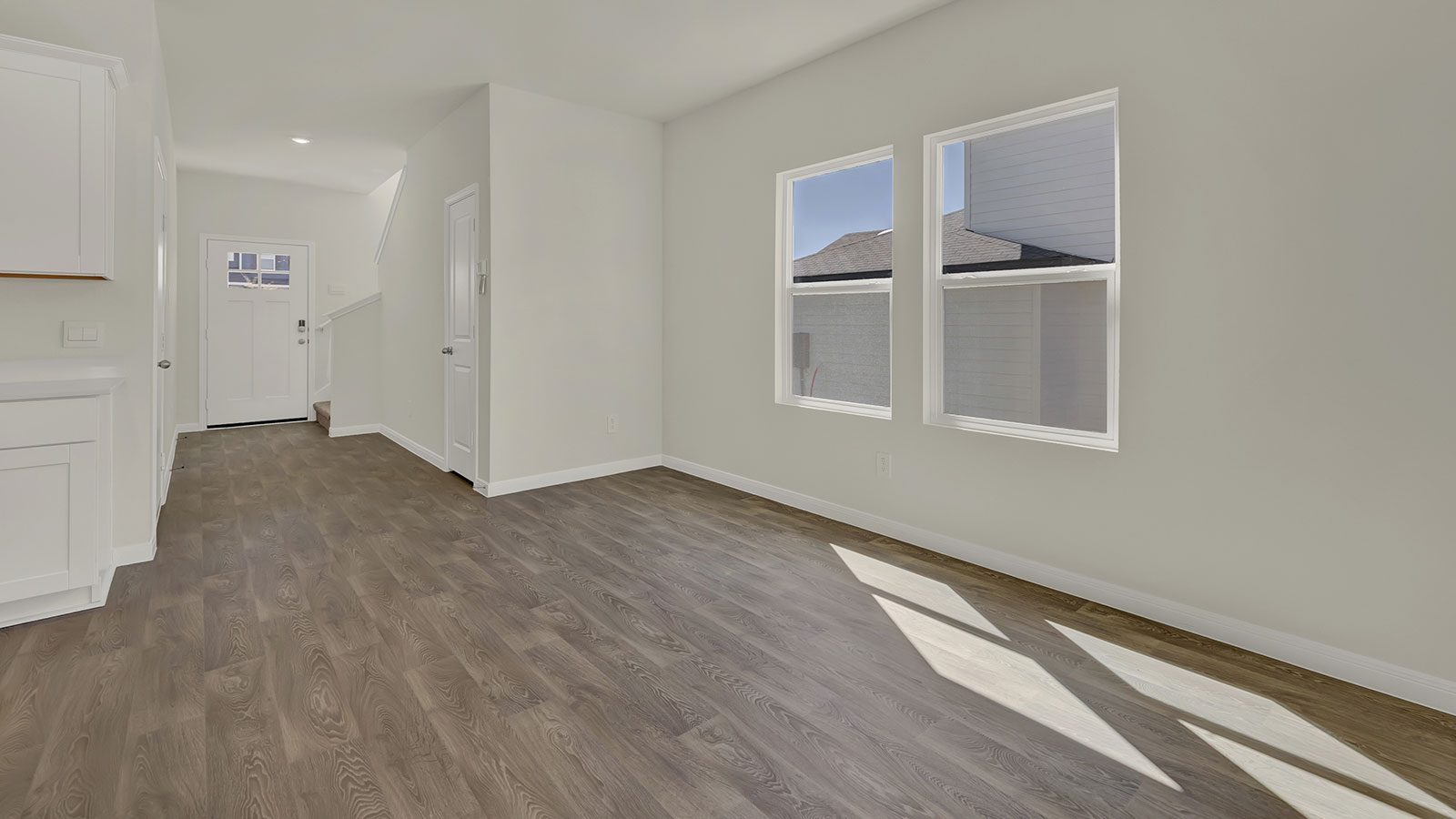 Kitchen view toward the front door and staircase showing clear sightlines and functional layout.
