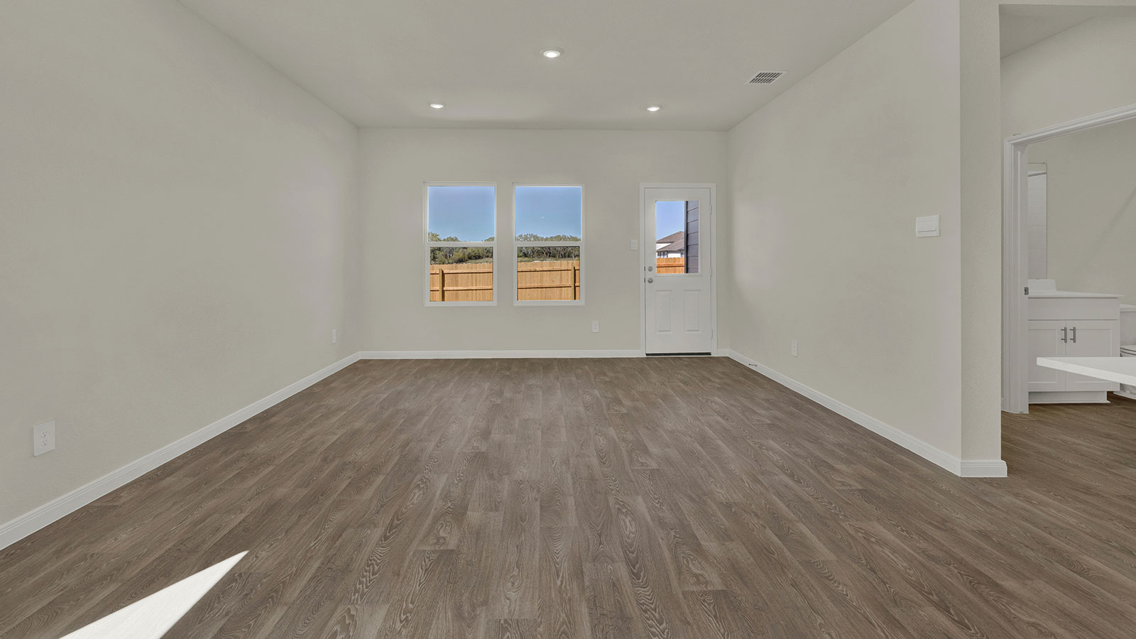 Living room designed for flexibility with seating space and connection to kitchen and dining areas.