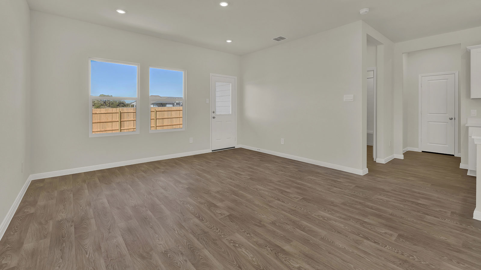 Living room view toward the front door emphasizing natural circulation and entry connection.