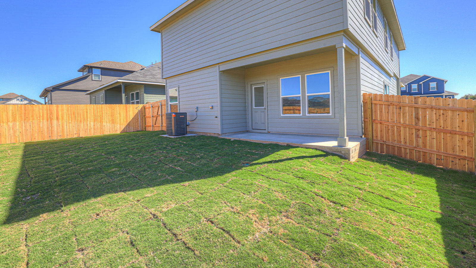 Backyard view featuring a covered patio supporting outdoor seating and indoor-outdoor living.