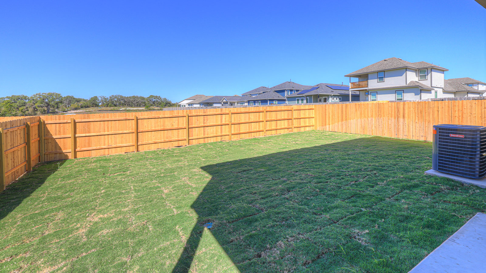 Backyard view showing open outdoor space and connection to the covered patio.