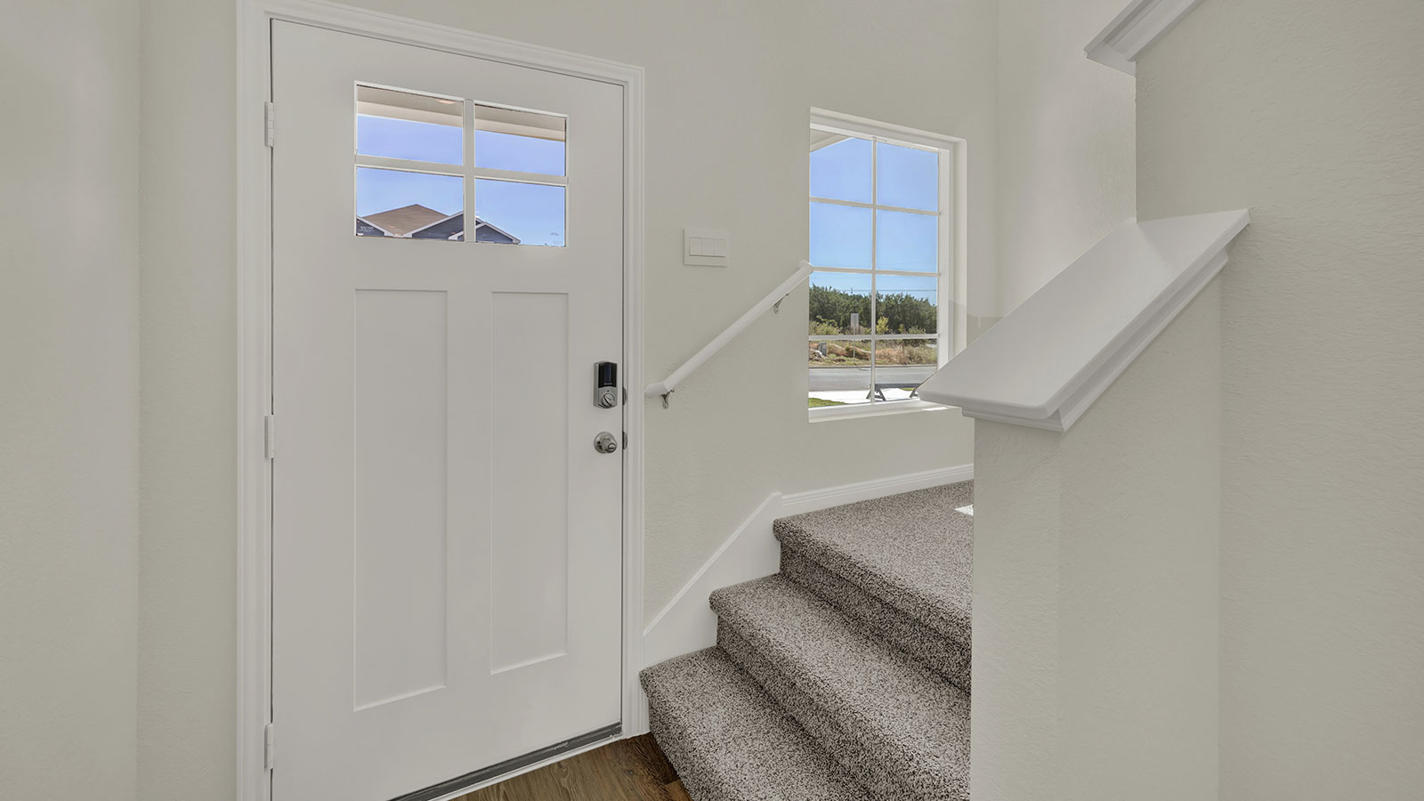 Foyer view with staircase looking back toward the residence highlighting open circulation and entry flow.