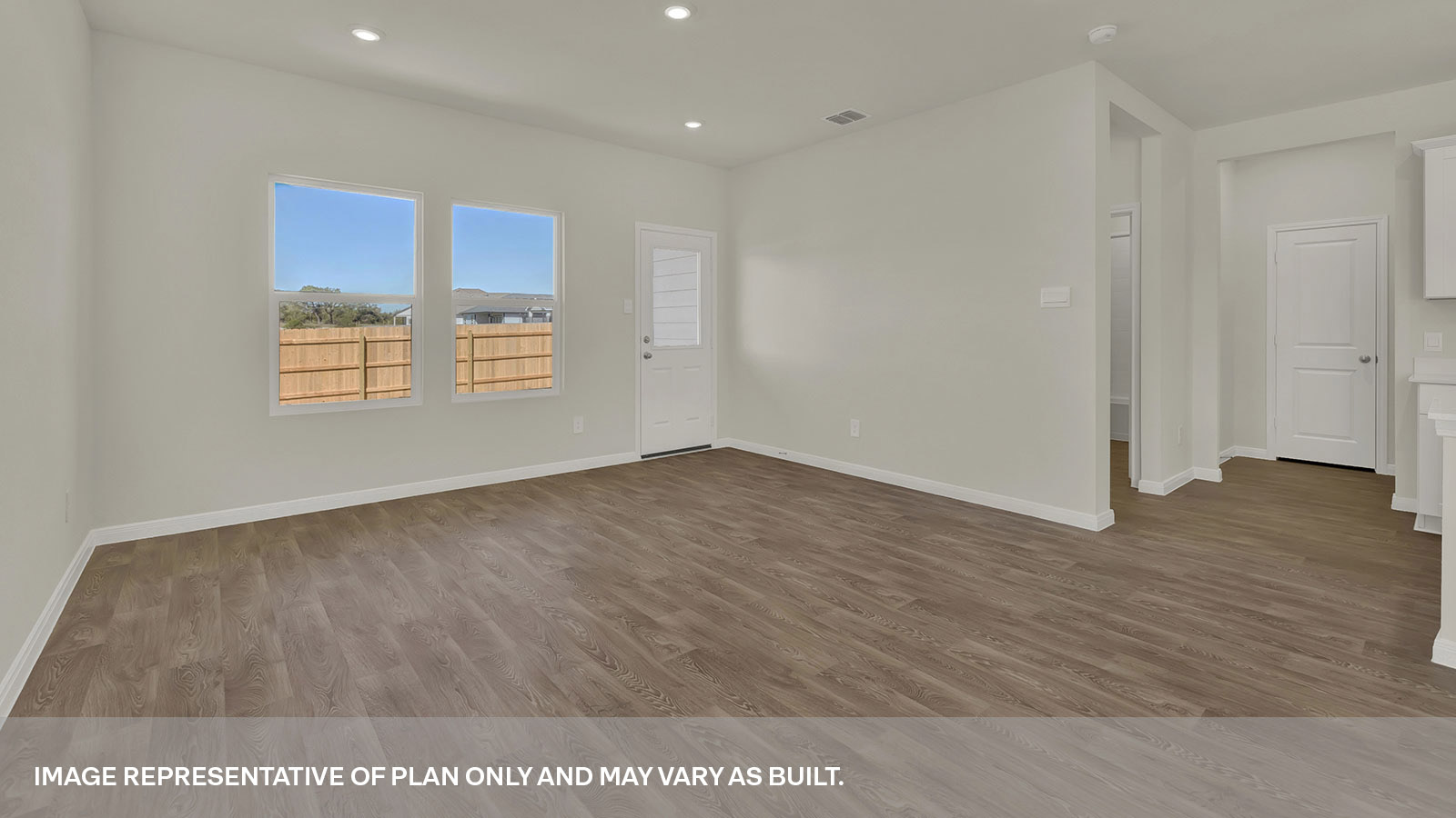 Living room with vinyl flooring, two windows, and a half lite exterior door.
