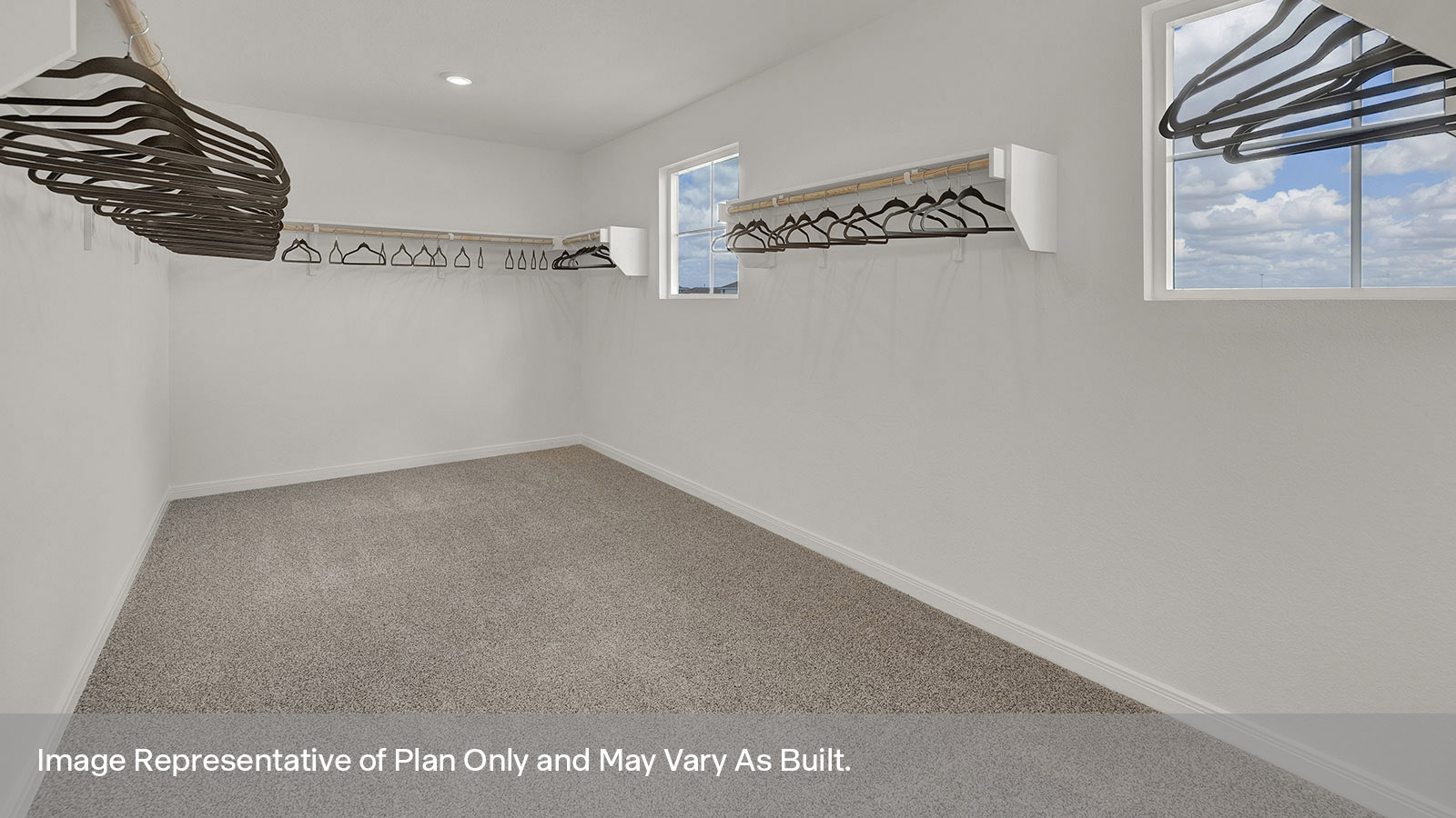 Main bedroom closet with carpeting and wooden shelving.