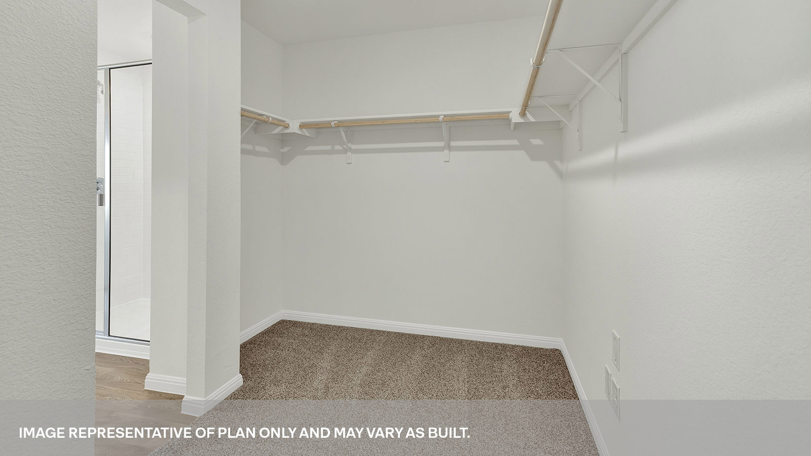 Main bedroom closet with carpeting and wooden shelving.