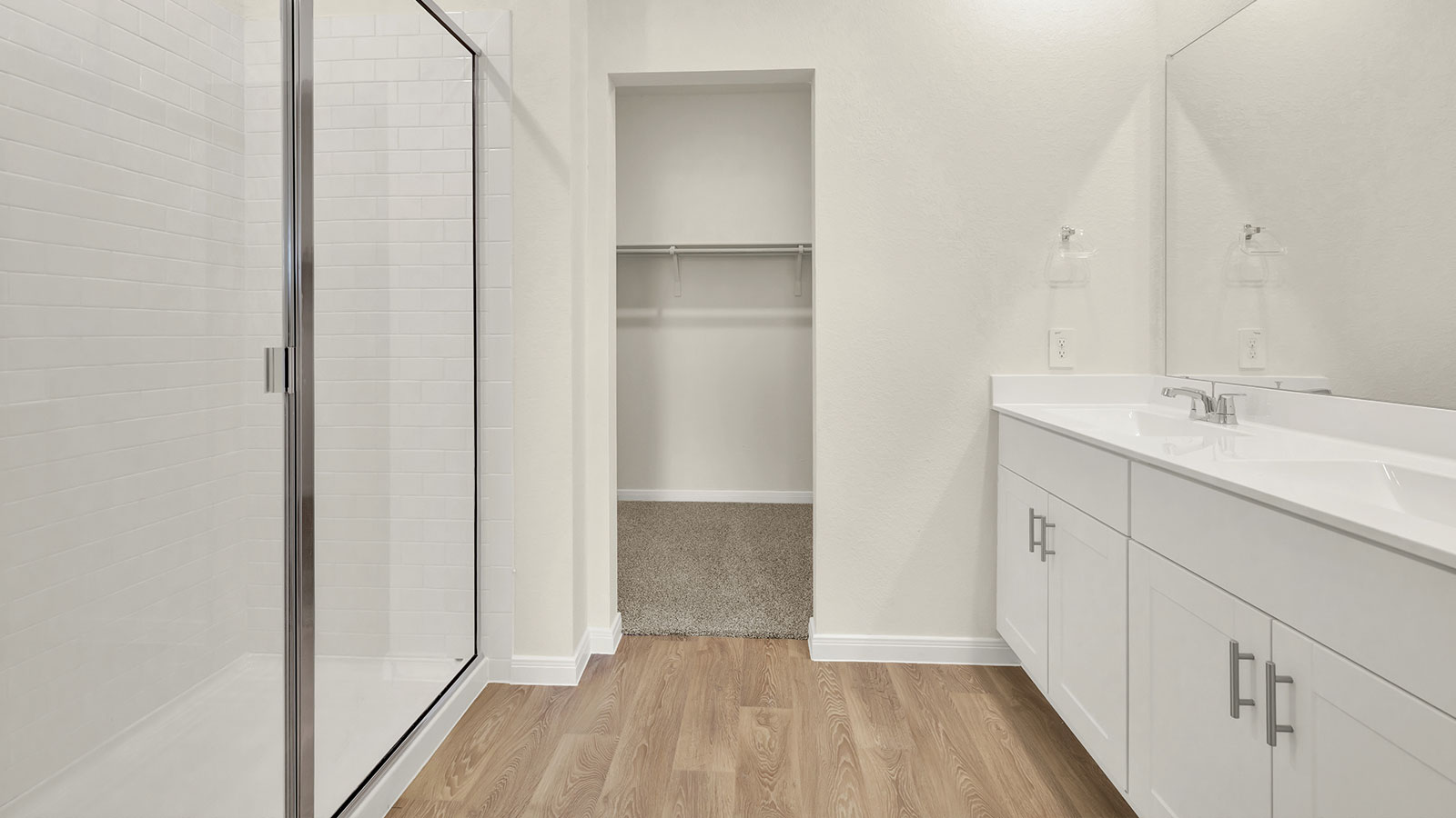 Main bathroom with double sink vanity and stand in shower.