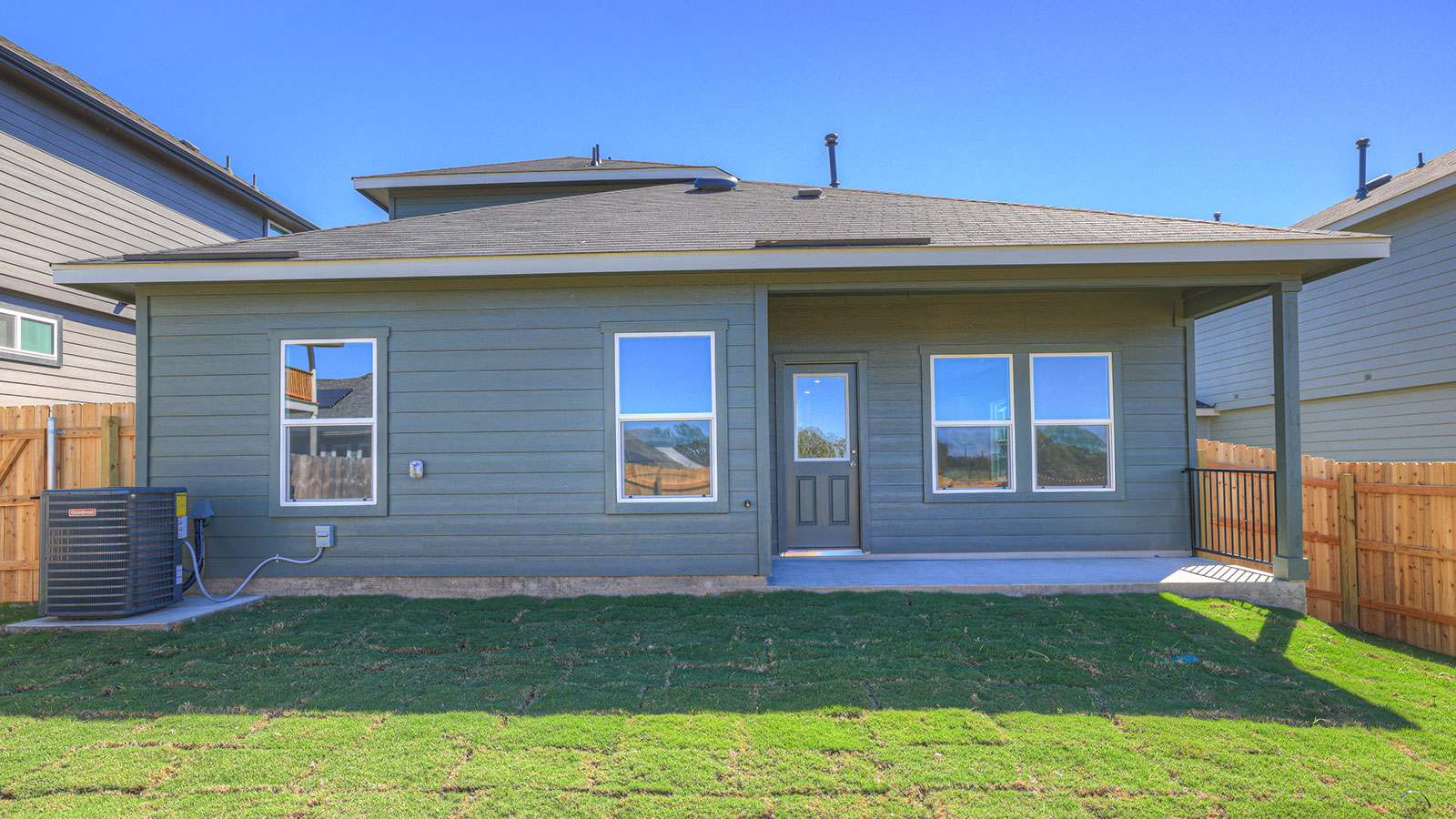 Covered patio with two windows and a half lite exterior door.