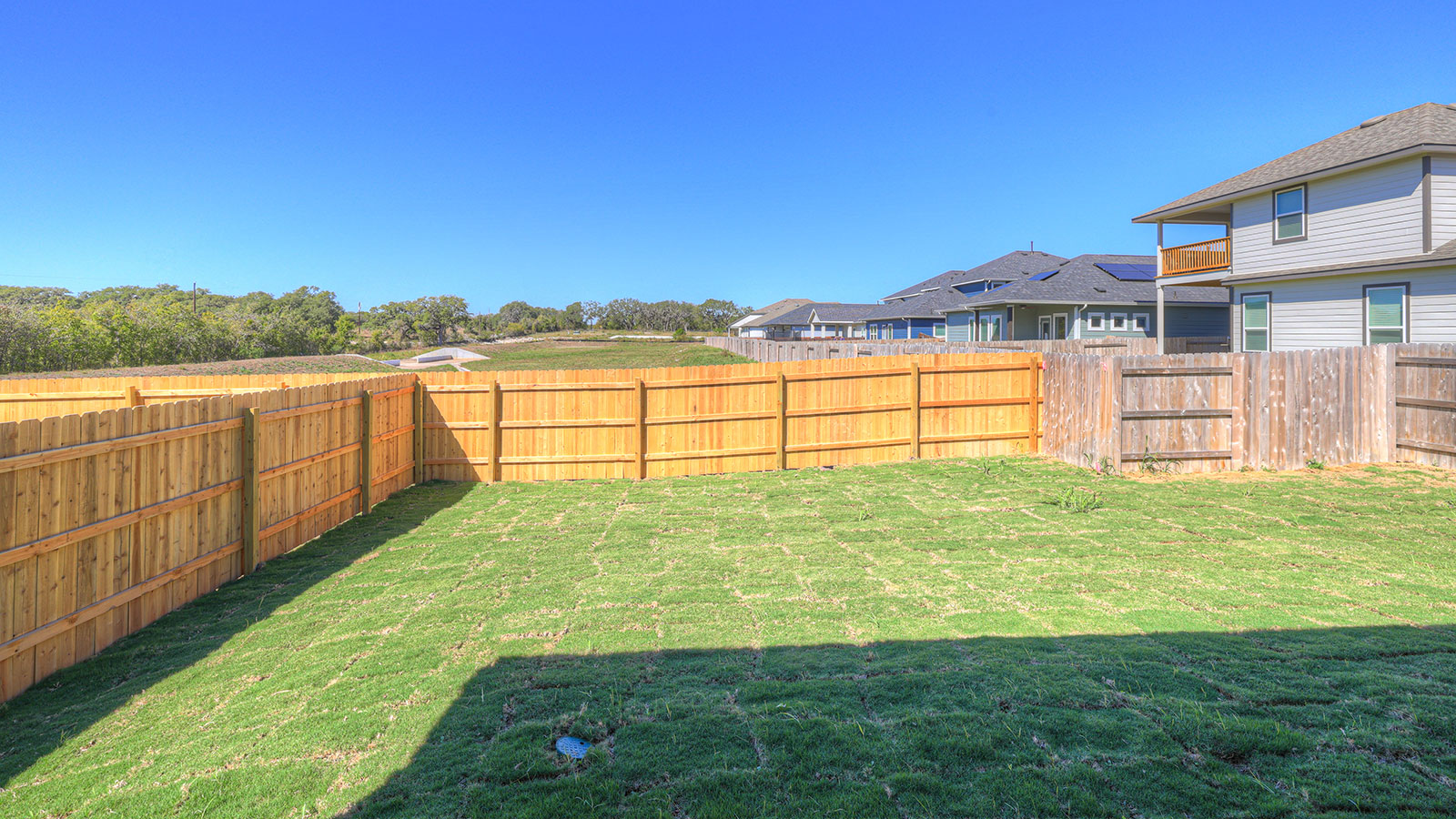 Covered patio and fully sodded backyard with privacy fence.