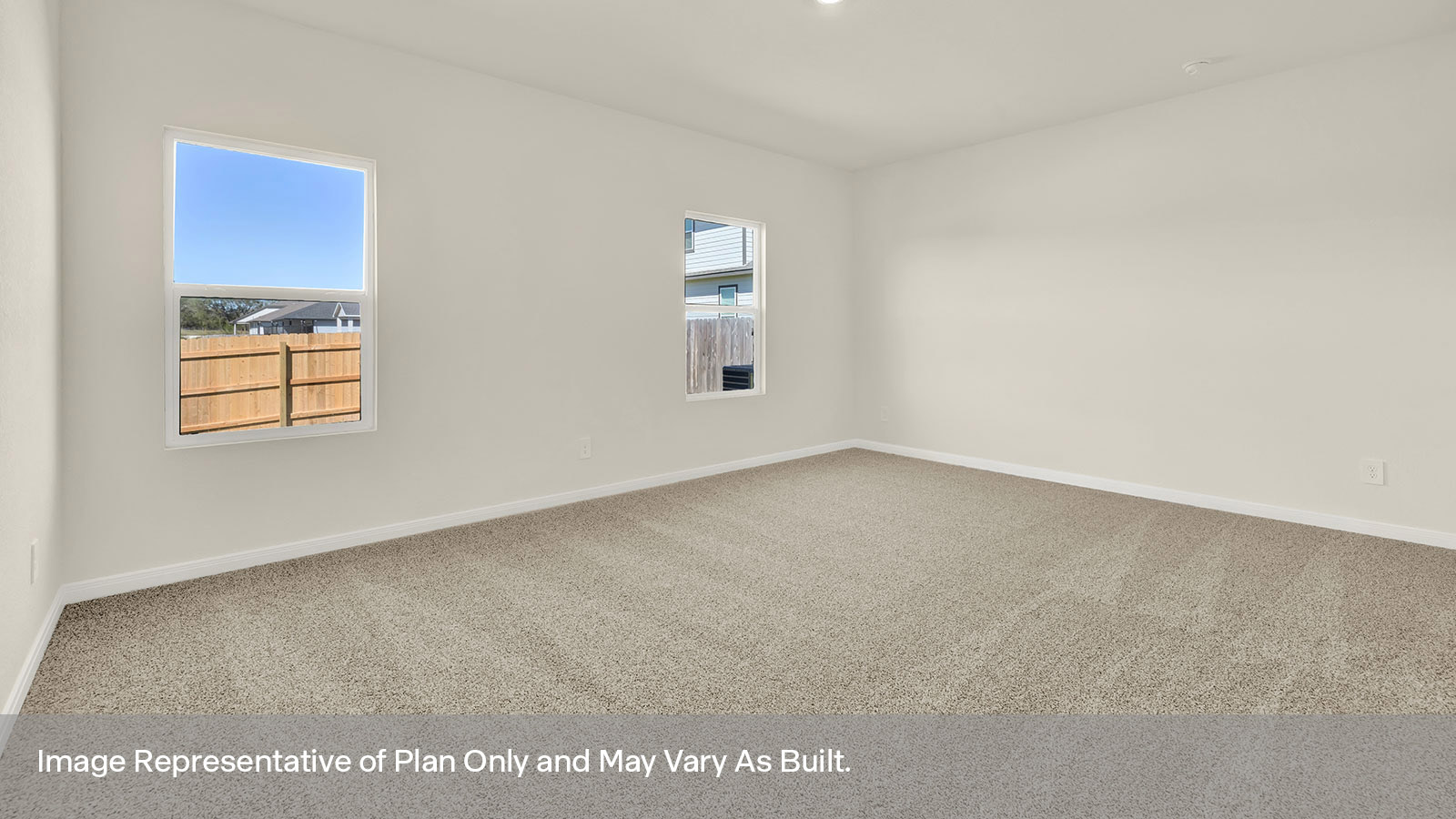 Main bedroom with carpeting and two windows.