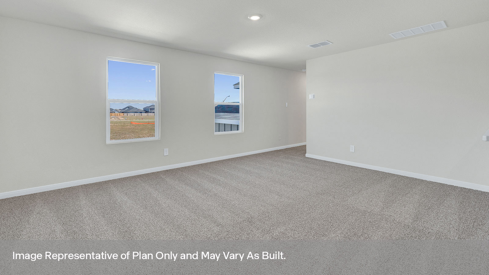 Gameroom off the staircase with carpeting and two windows.