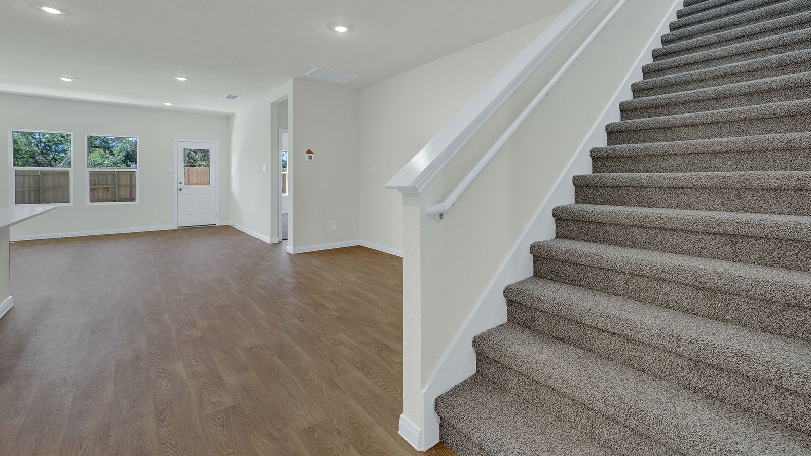 Living room with vinyl flooring and 2 windows.