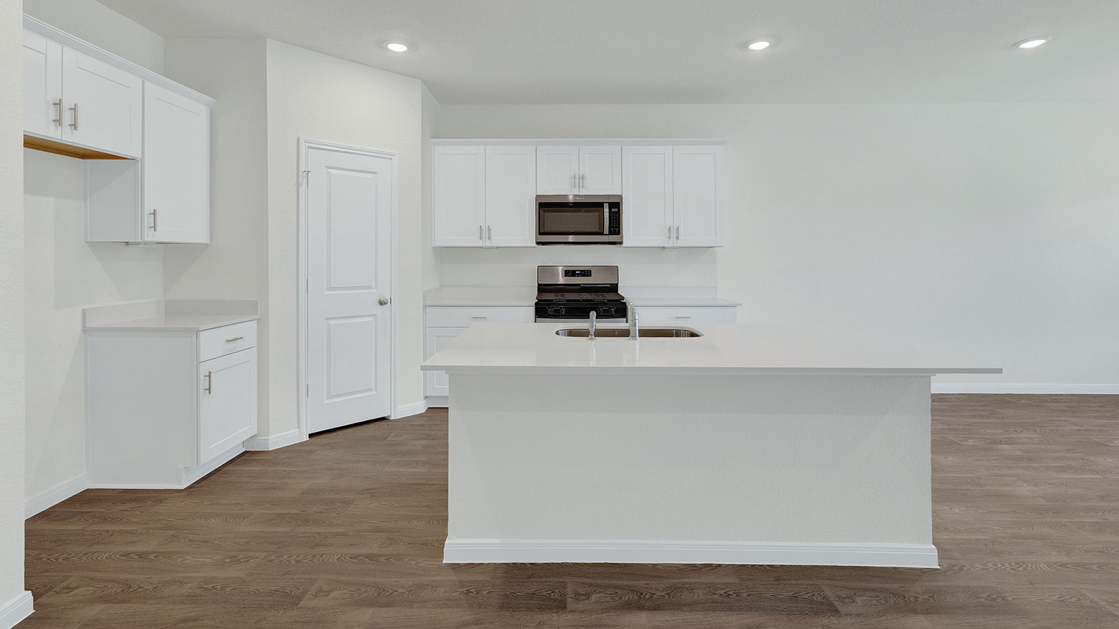 Kitchen island with granite countertops and stainless steel sink.