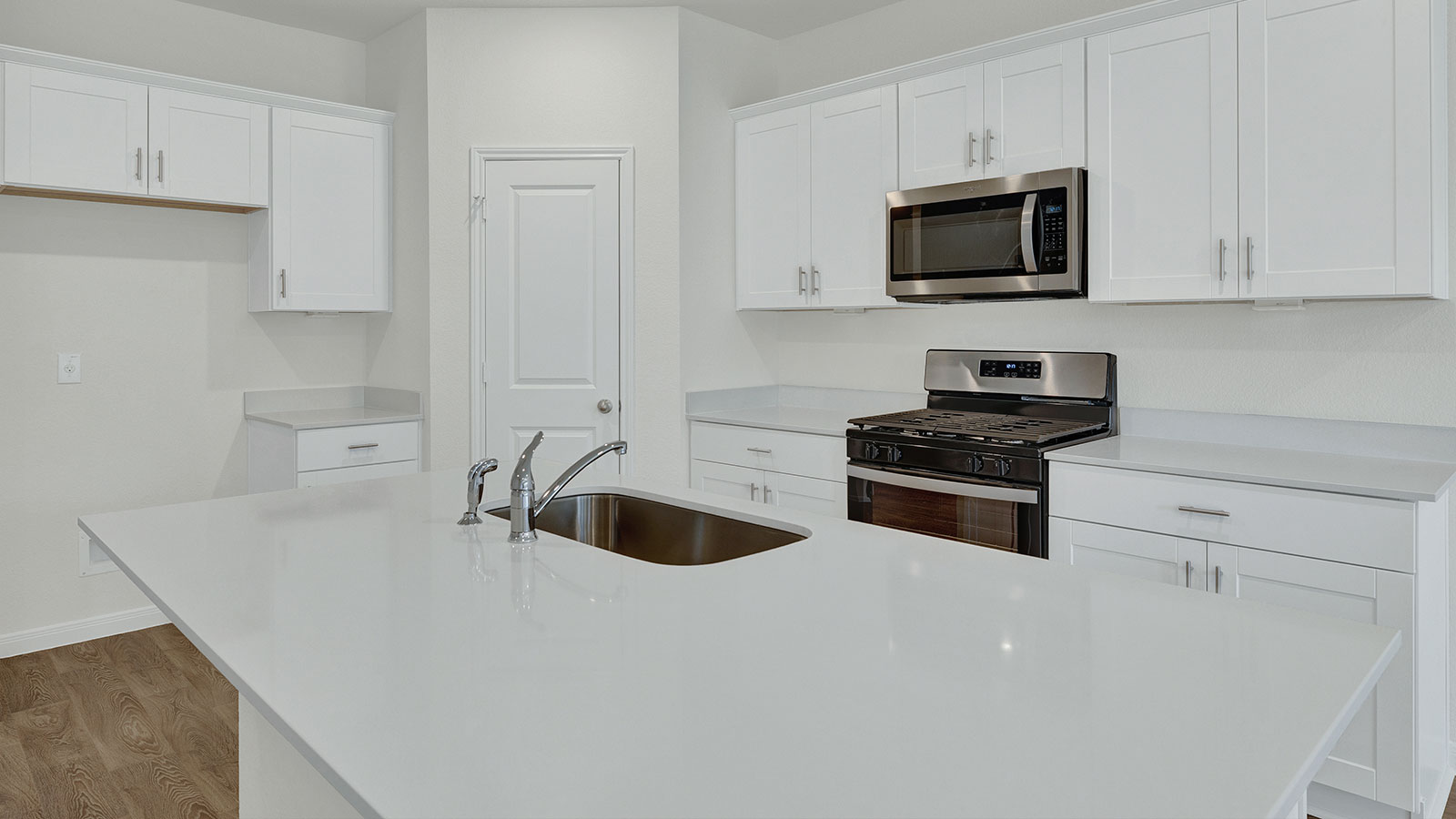 Kitchen island with granite countertops and stainless steel sink.