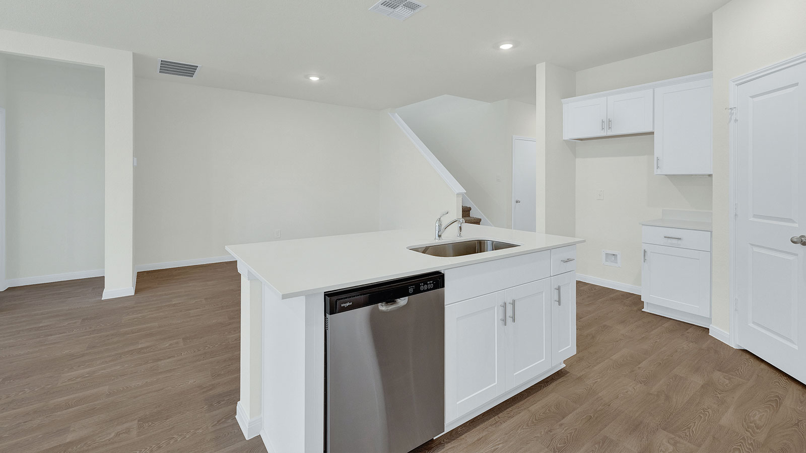 Kitchen island with granite countertops and stainless steel sink.