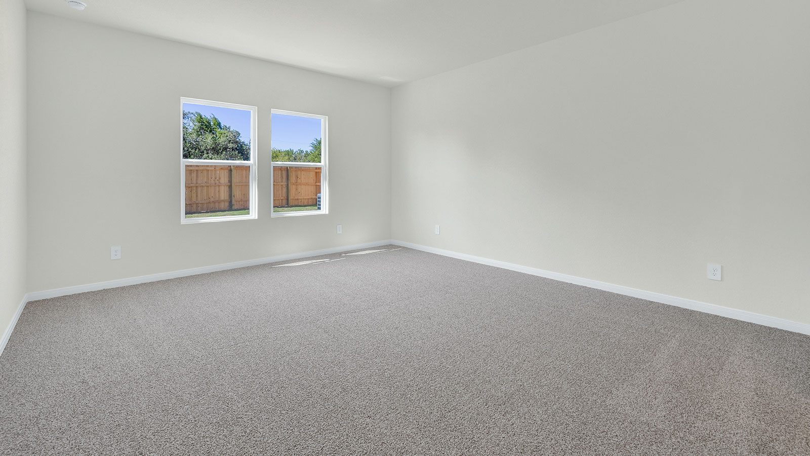 Main bedroom with carpeting and 2 windows.