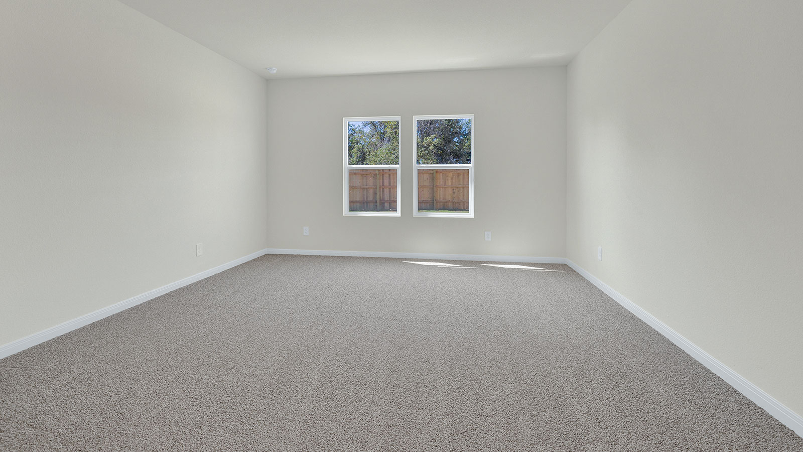 Main bedroom with carpeting and 2 windows.