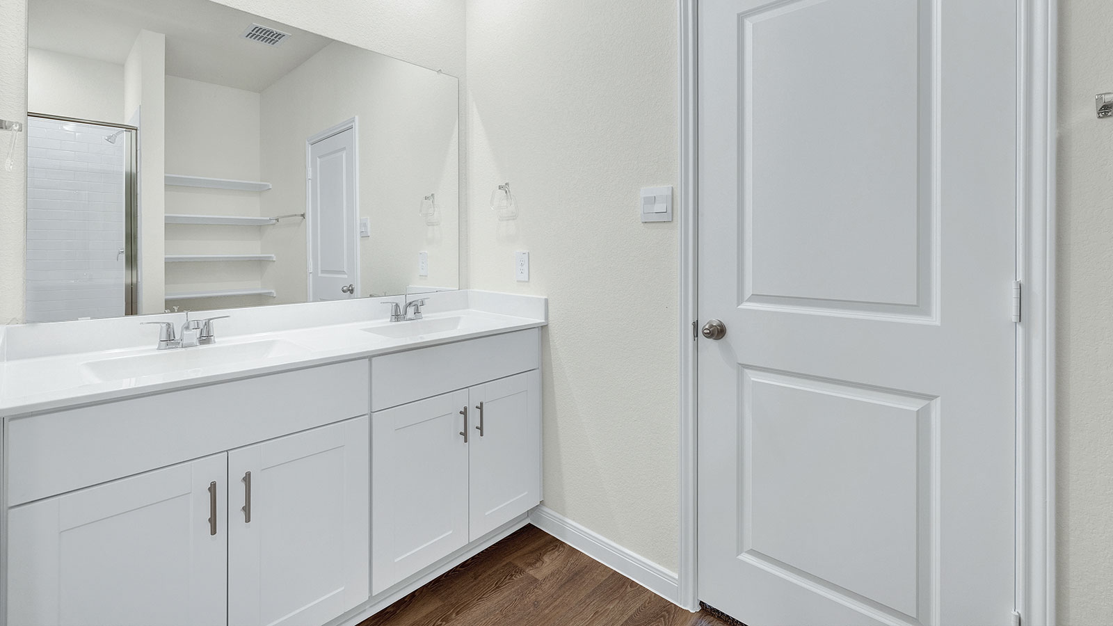 Main bathroom with double sink vanity and shower.