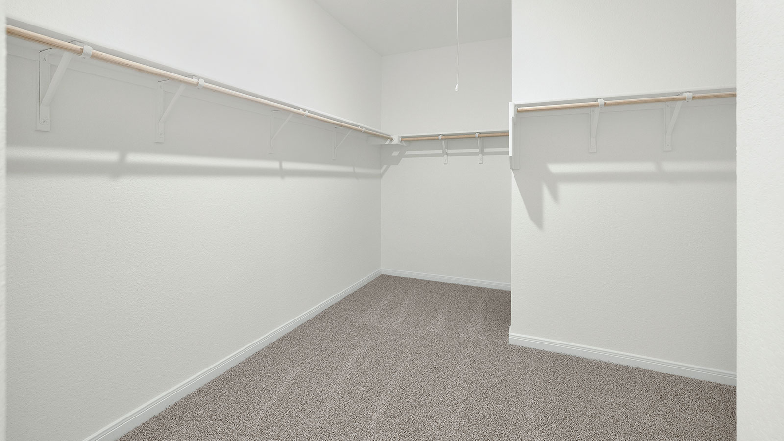 Main bedroom closet with carpeting and wooden shelving.