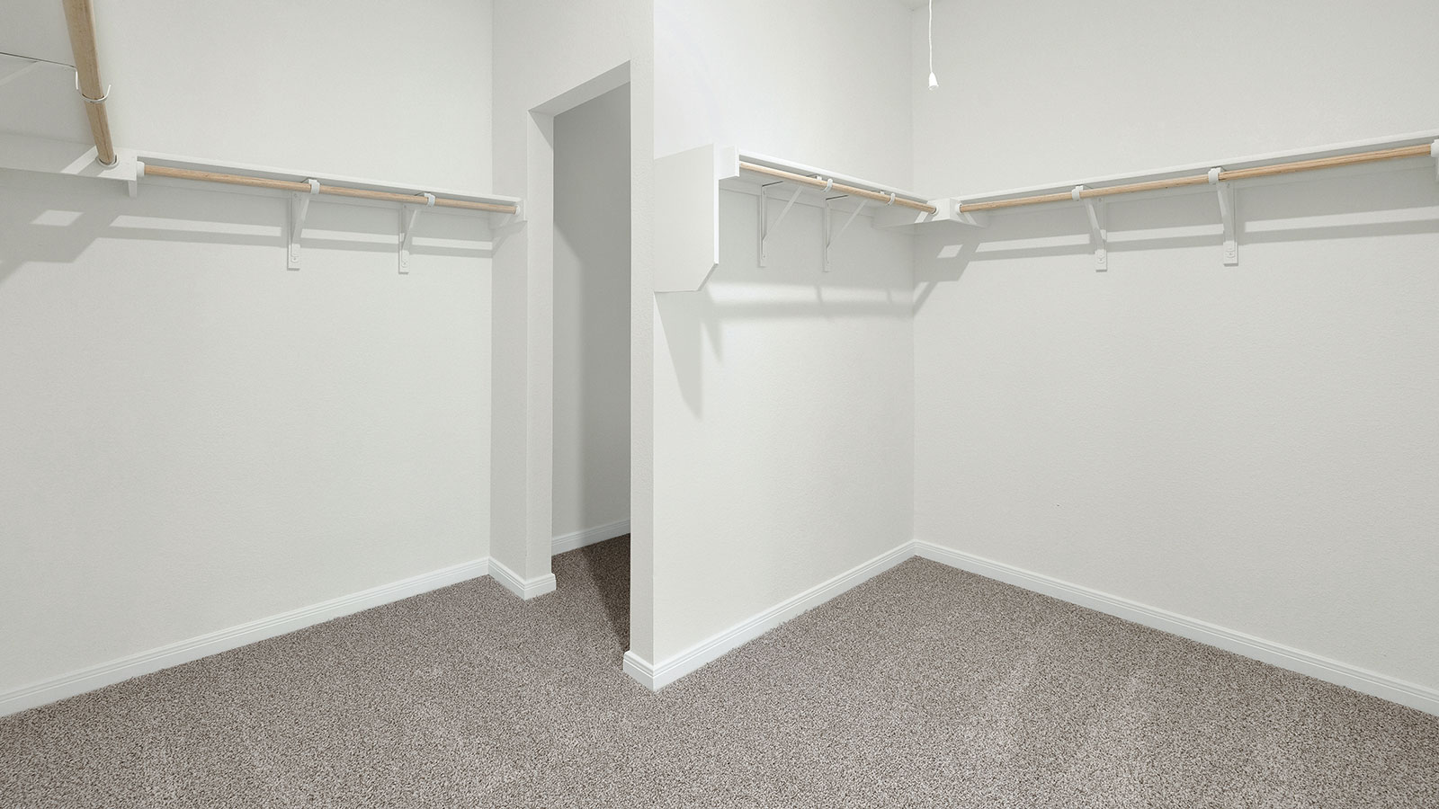 Main bedroom closet with carpeting and wooden shelving.