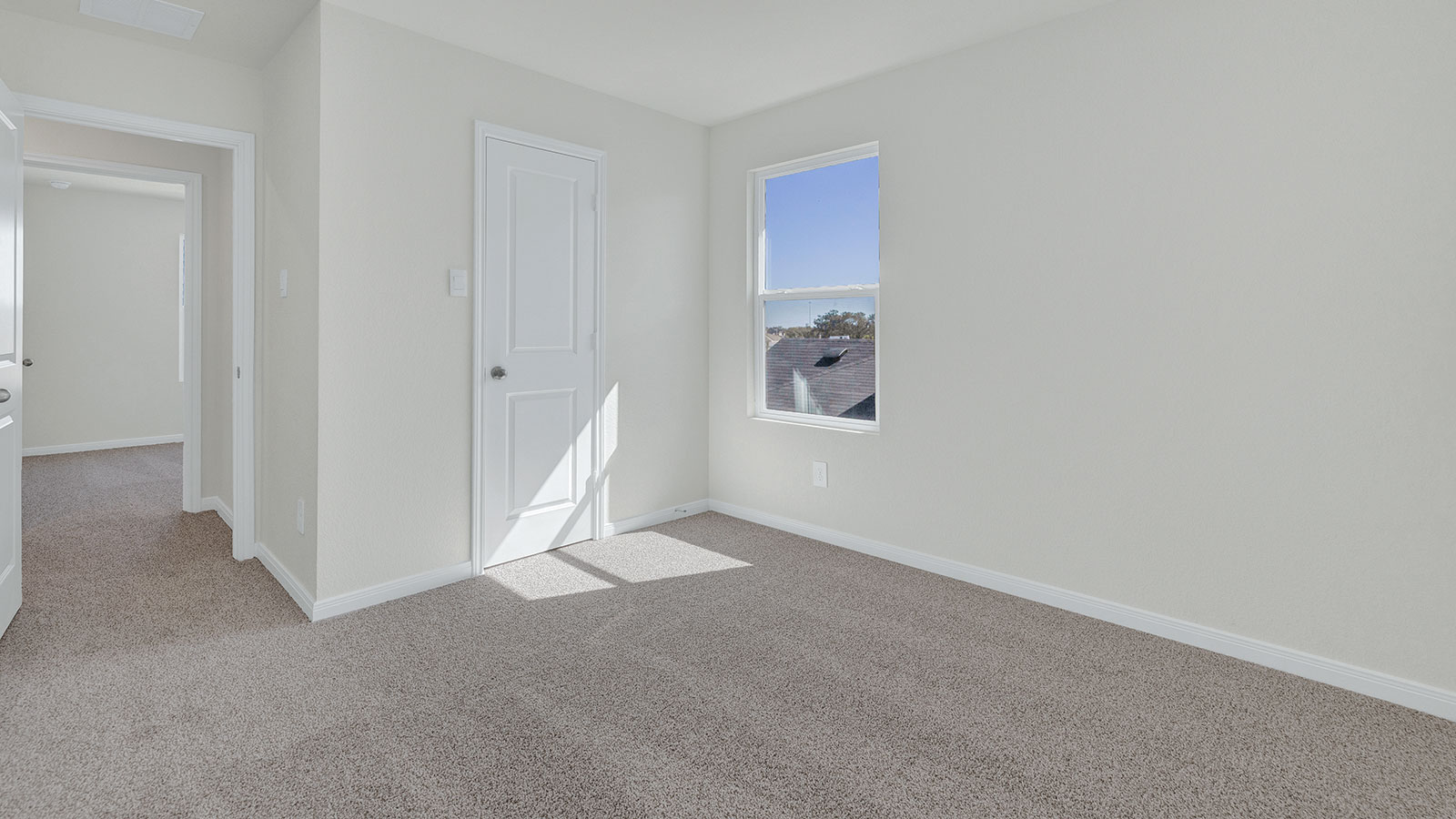 Bedroom with carpeting and one window.