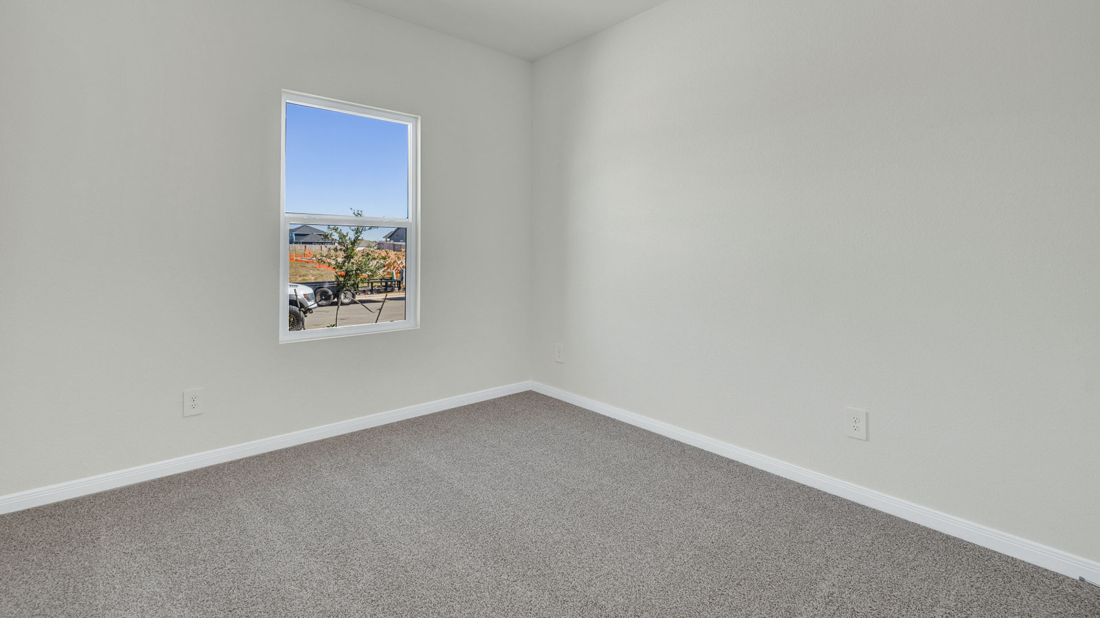 Bedroom with carpeting and one window.