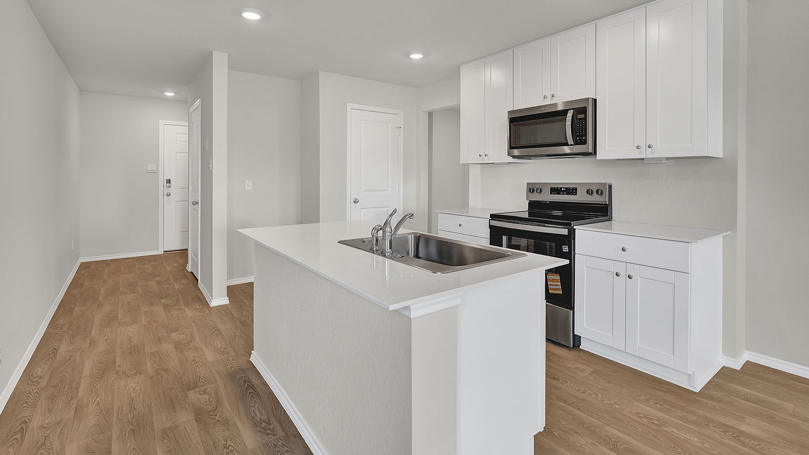 Kitchen with kitchen island and entry hallway.