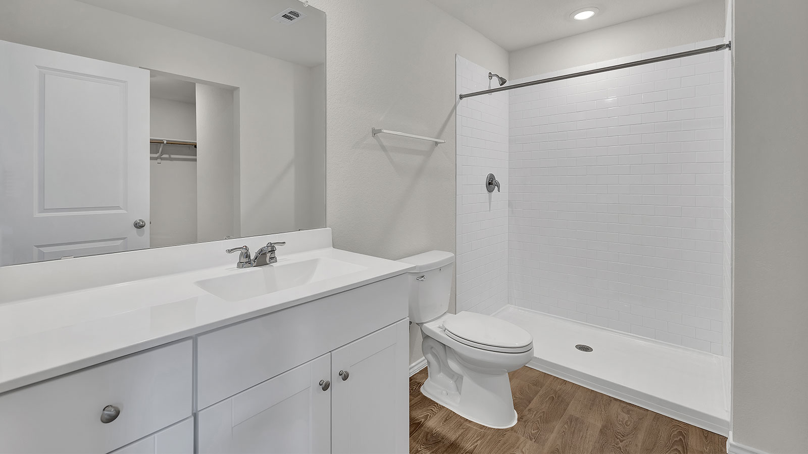 Main bathroom with vanity, toilet, and tiled shower.