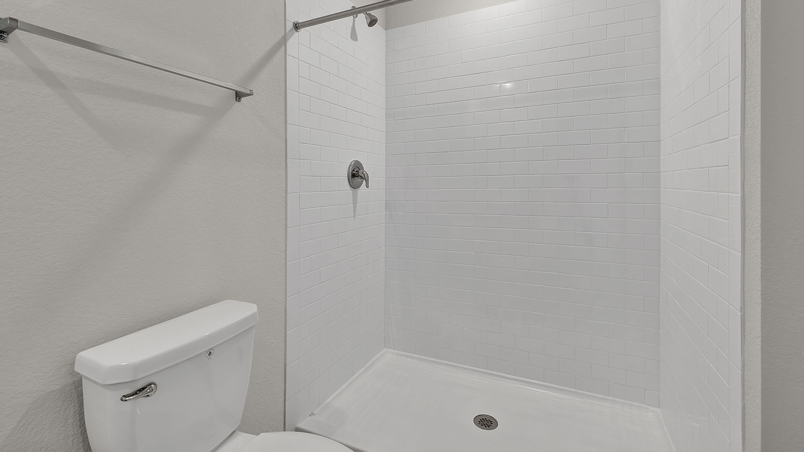 Main bathroom with vanity, toilet, and tiled shower.