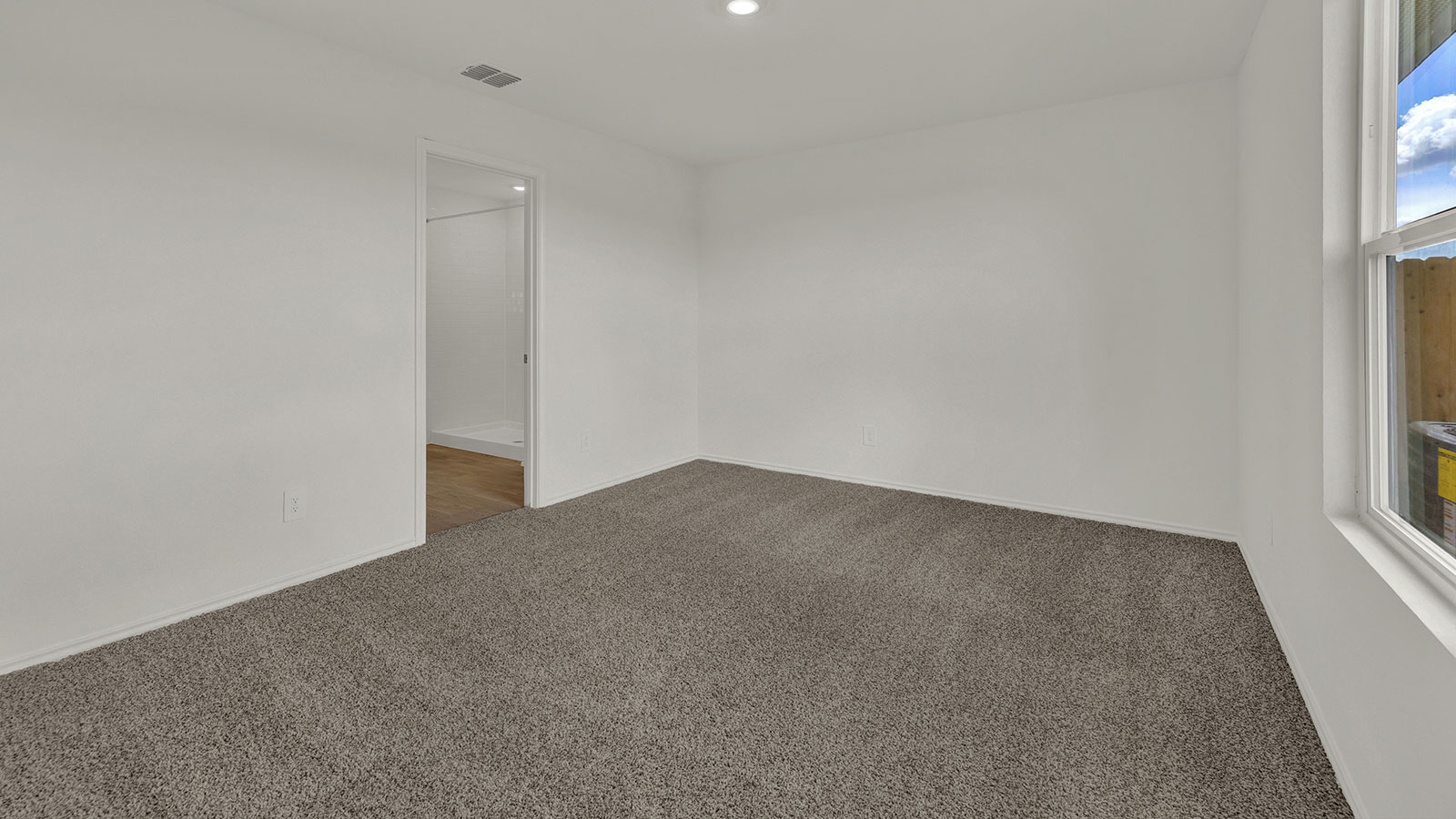 Main bedroom with carpeting and one window.