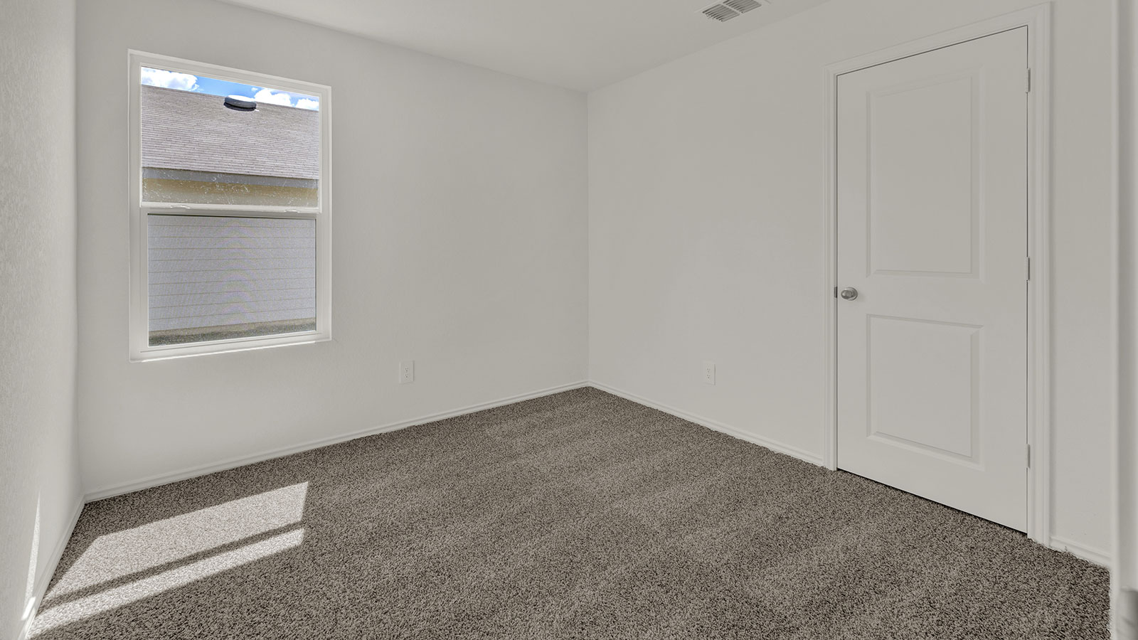 Bedroom with carpeting and one window.