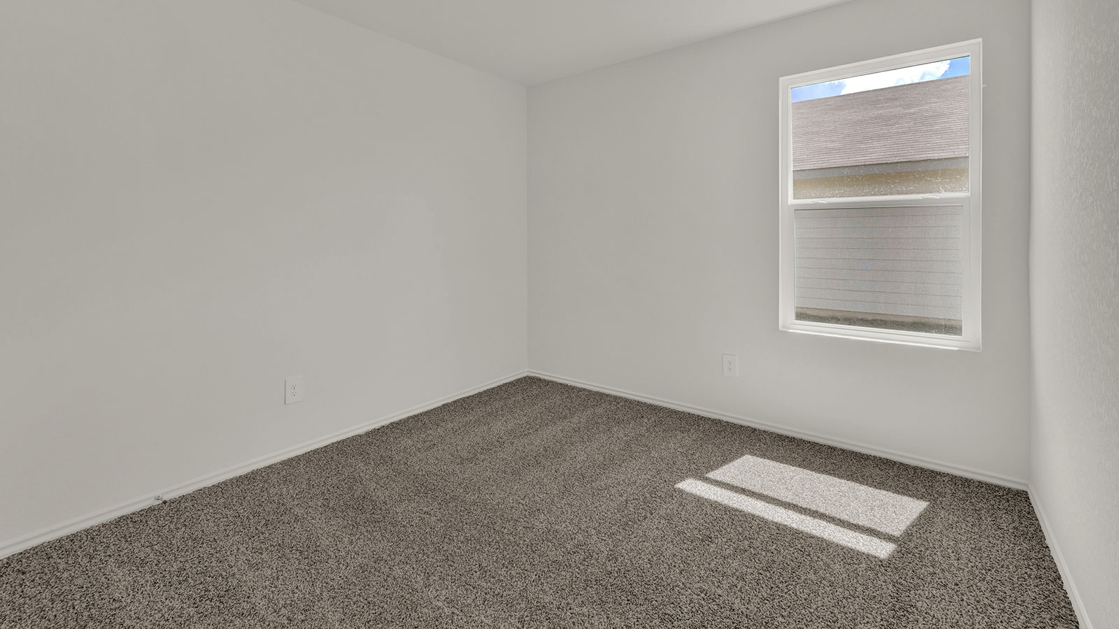 Bedroom with carpeting and one window.