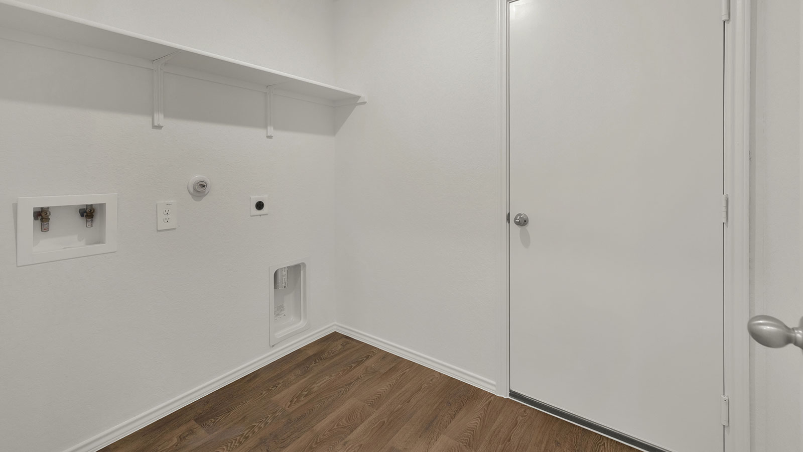 Laundry room with washer/dryer connections and wooden shelving.