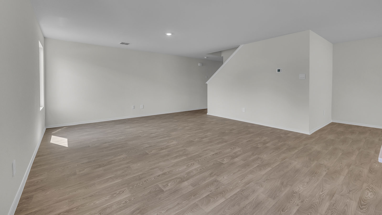 Living room with vinyl flooring, one window, and a half lite exterior door.