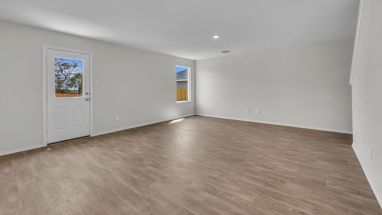 Living room with vinyl flooring, one window, and a half lite exterior door.