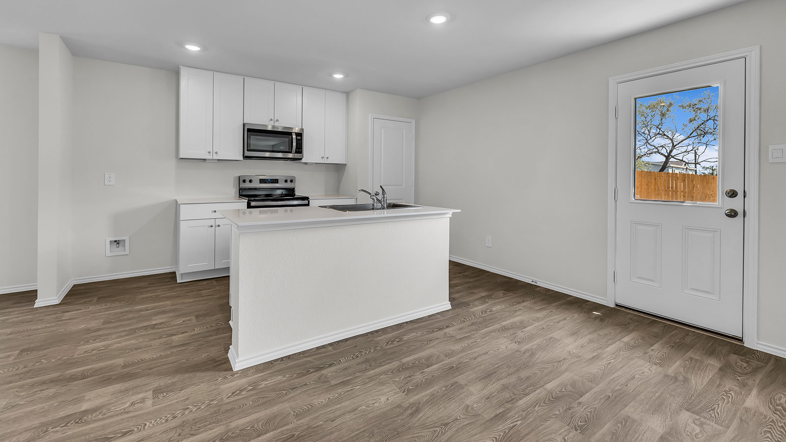 Kitchen island with quartz countertops and stainless steel appliances.