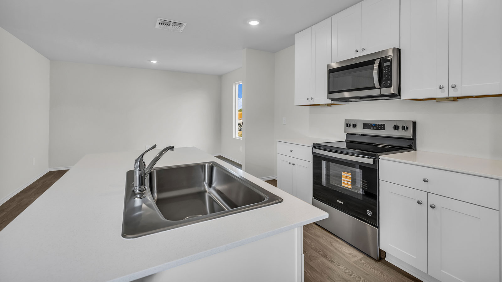 Kitchen island with quartz countertops and stainless steel appliances.