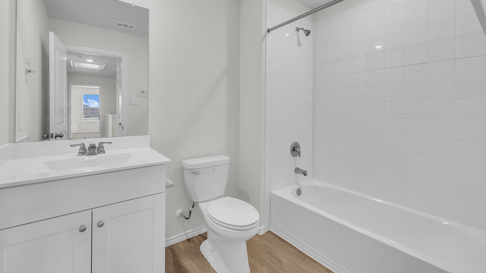 Hall bathroom with sink, toilet, and tub with tile surround.
