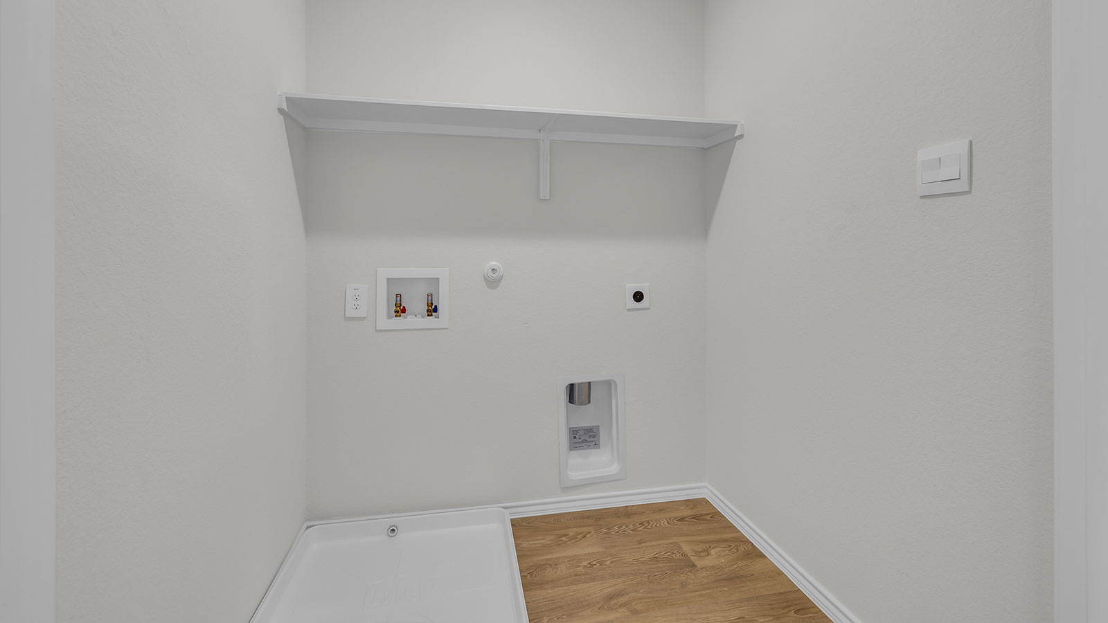 Laundry room with washer/dryer connections and wooden shelving.