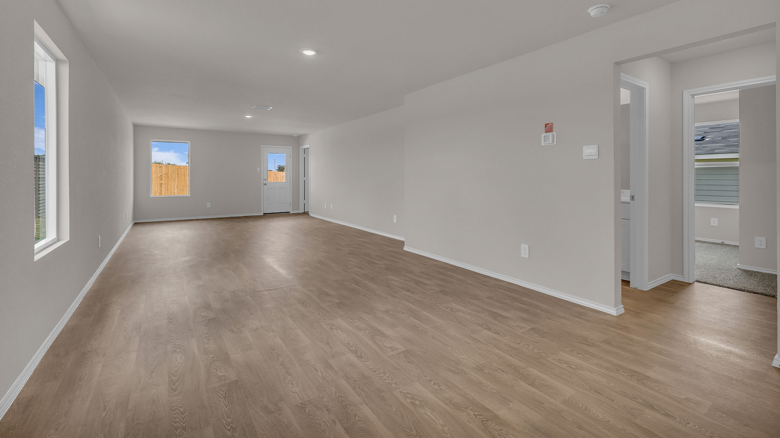 Dining room with vinyl flooring and opening to the living room.